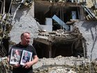 A teacher with the portraits of students who died when the dormitory came under attack. 