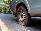 Two men have been charged after police alleged a woman was threatened with a knife and dragged toward an SUV while changing a flat tyre.