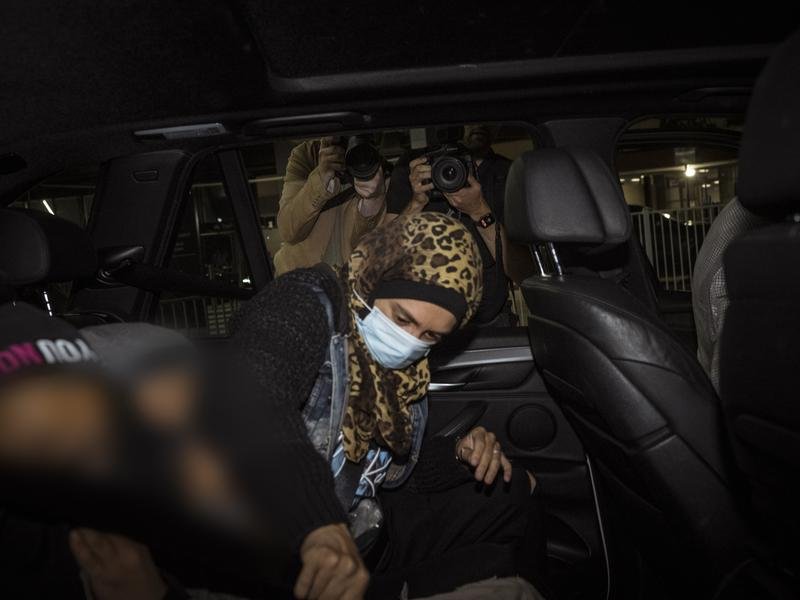 A so-called ISIS bride, one of two to land with their families in Melbourne, leaves the airport. 