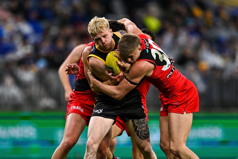 West Coast’s Ryan Maric takes on two Essendon players.