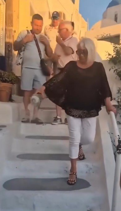 The woman sprinkling what is believed to be cremated remains. 
