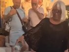 The woman empties what appears to be ashes onthe streets of Oia in Santorini