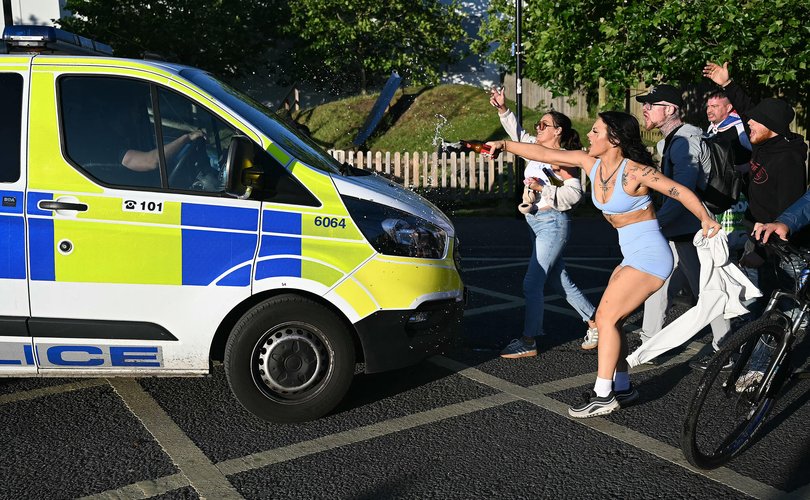 Demonstrators attack a police van.