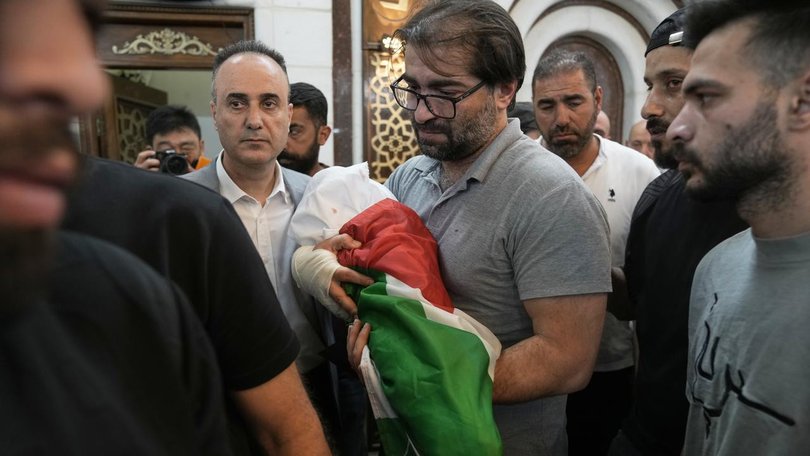 Sam Fahd Abu Haikal, wrapped in a white shroud ?and a Palestinian flag, has been buried in Hebron. (AP PHOTO)