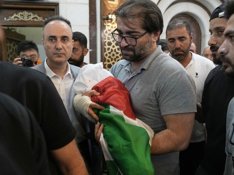 Sam Fahd Abu Haikal, wrapped in a white shroud ?and a Palestinian flag, has been buried in Hebron. (AP PHOTO)
