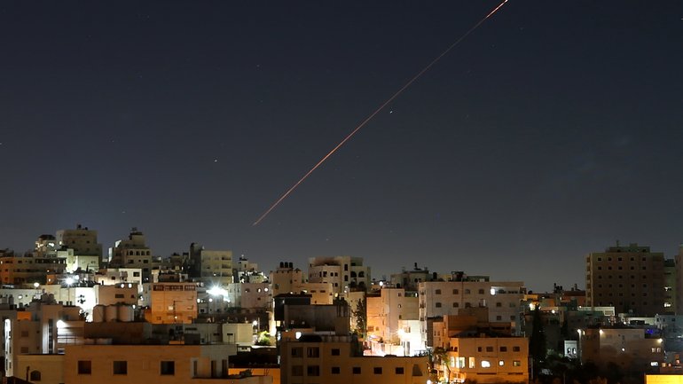 Missiles launched from Iran toward Israel are seen in the sky over the West Bank city of Hebron.