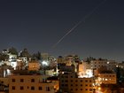 Missiles launched from Iran toward Israel are seen in the sky over the West Bank city of Hebron.