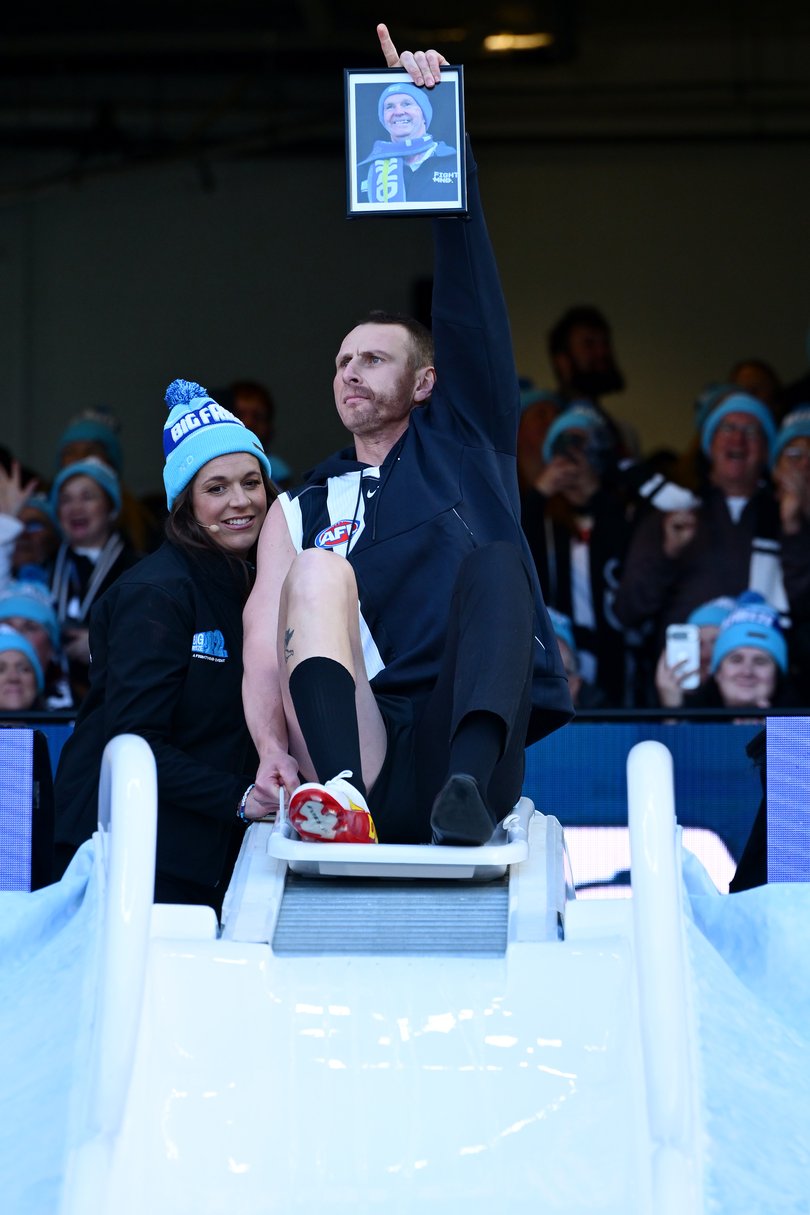 MELBOURNE, AUSTRALIA - JUNE 08: Dan Gorringe goes down the slide as Josh Fraser for FightMND Big Freeze 12 ahead of the round 13 AFL match between Collingwood Magpies and Melbourne Demons at Melbourne Cricket Ground, on June 08, 2026, in Melbourne, Australia. (Photo by Quinn Rooney/Getty Images)