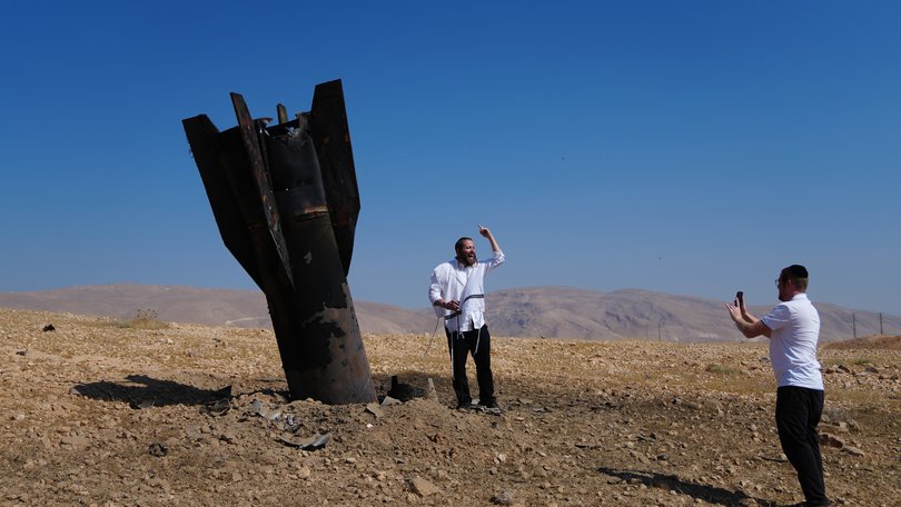People take their photos beside the wreckage of an Iranian missile that landed near the West Bank city of Jericho Monday, June 8, 2026. (AP Photo/Mahmoud Illean)