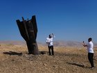 People take their photos beside the wreckage of an Iranian missile that landed near the West Bank city of Jericho Monday, June 8, 2026. (AP Photo/Mahmoud Illean)