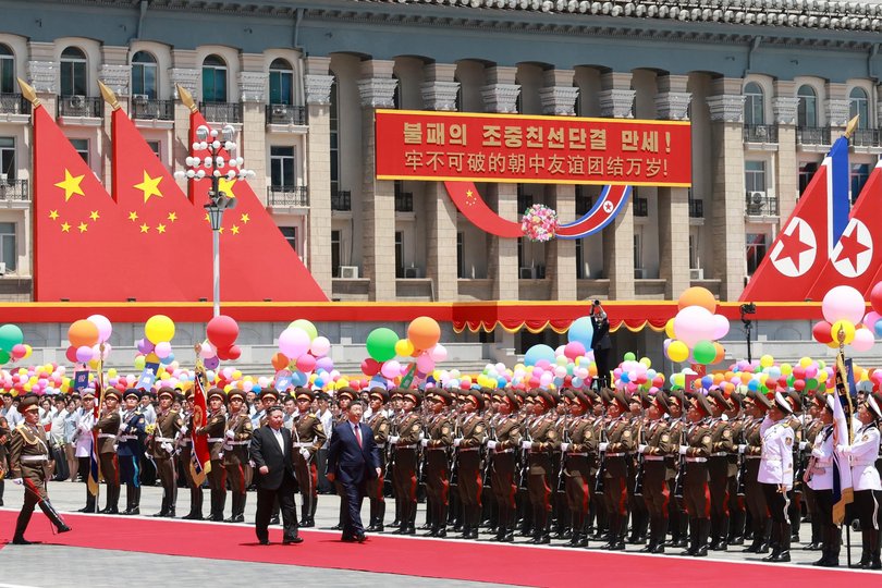 In this photo released by Xinhua News Agency, Chinese President Xi Jinping and North Korean leader Kim Jong Un inspect the honor guard of the three services of the Korean People's Army in Pyongyang.