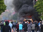 People watched on as a vehicle burned during a protest following a stabbing in Belfast. (AP PHOTO)