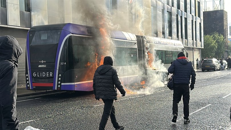 A Glider bus, set fire by protesters, on the Newtownards Road in east Belfast, as disorder flared during an anti-immigration demonstration.