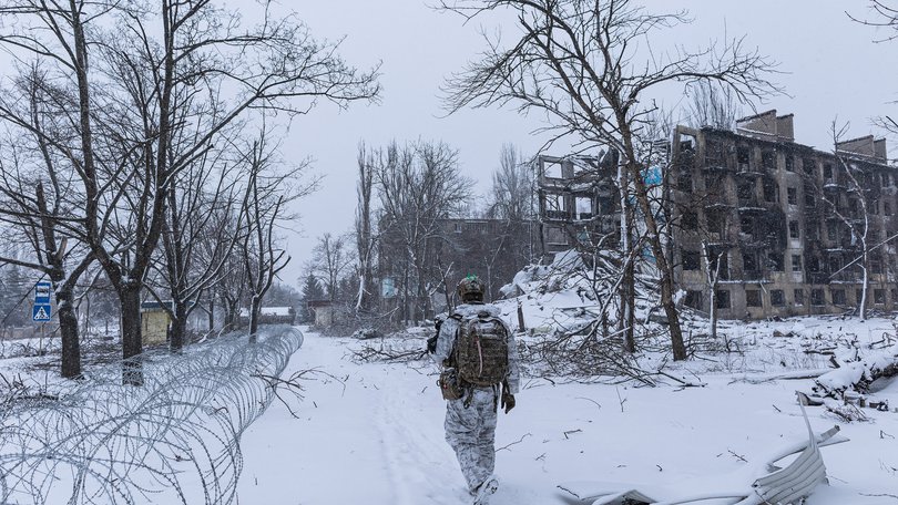Oleg, a Ukrainian serviceman from the 24th Brigade, walks in front of a building damaged by Russian bombing in Kostiantynivka, Ukraine.