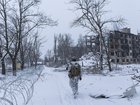 Oleg, a Ukrainian serviceman from the 24th Brigade, walks in front of a building damaged by Russian bombing in Kostiantynivka, Ukraine.