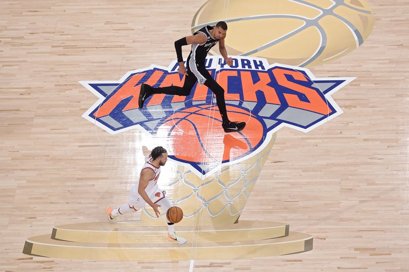 Jalen Brunson #11 of the New York Knicks dribbles against Victor Wembanyama .