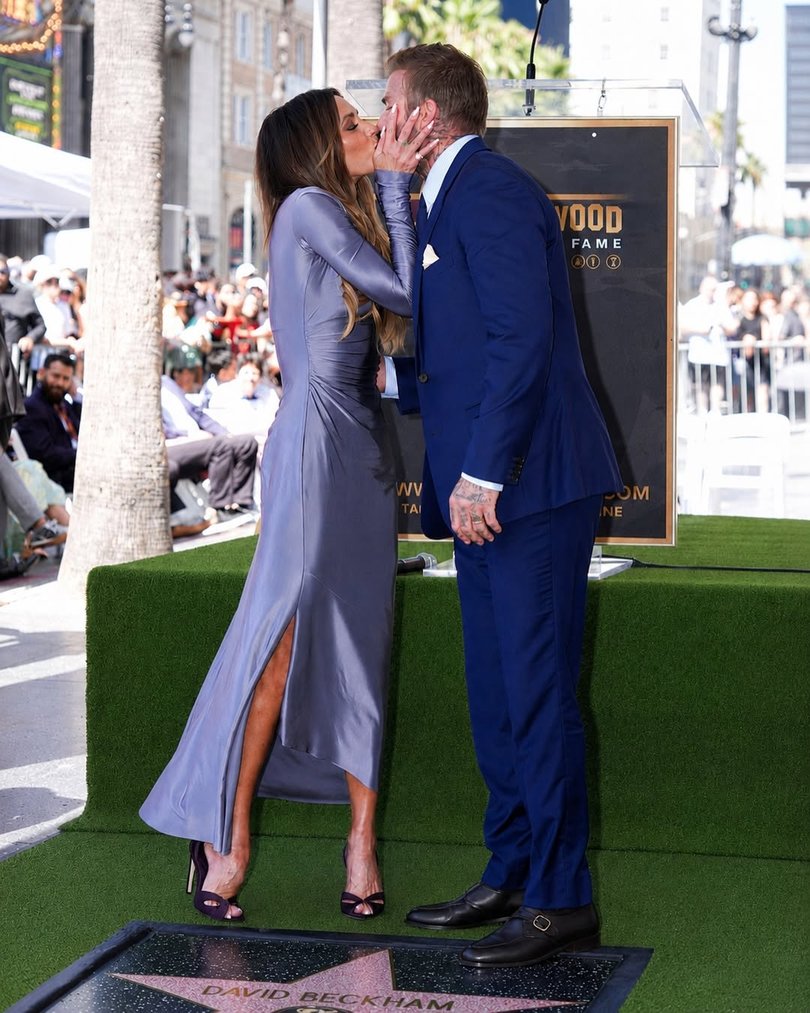 Victoria giveshusband David Beckham a big kiss to celebrate.