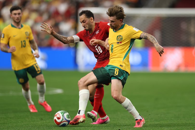 VANCOUVER, BRITISH COLUMBIA - JUNE 13: Hakan Calhanoglu #10 of Turkiye and Connor Metcalfe #8 of Australia compete for the ball during the FIFA World Cup 2026 Group D match between Australia and Türkiye at BC Place Vancouver on June 13, 2026 in Vancouver, British Columbia. (Photo by Dean Mouhtaropoulos/Getty Images)