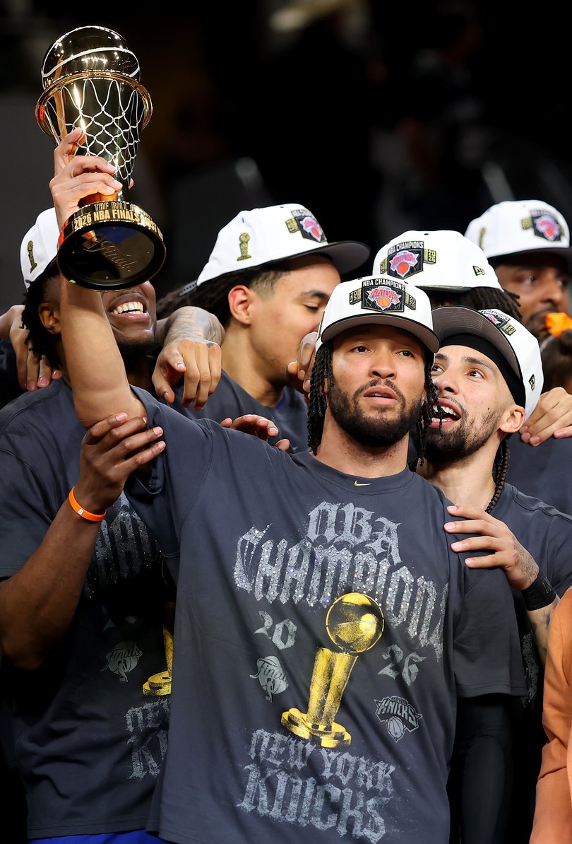 Jalen Brunson lifts the Bill Russell NBA Finals Most Valuable Player Award trophy.