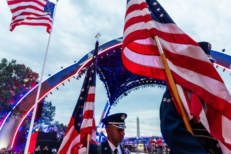 Members of the military carry American flags.