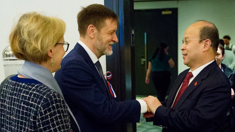 Mikhail Petrakov and his wife Irina greet Chinese Ambassador Xiao Qian.