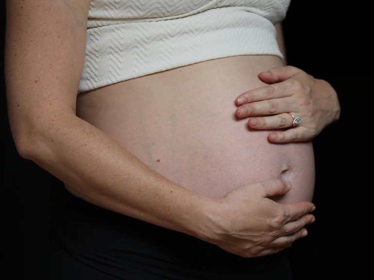 A coroner is probing the death of a woman who chose to give birth without any medical professionals.