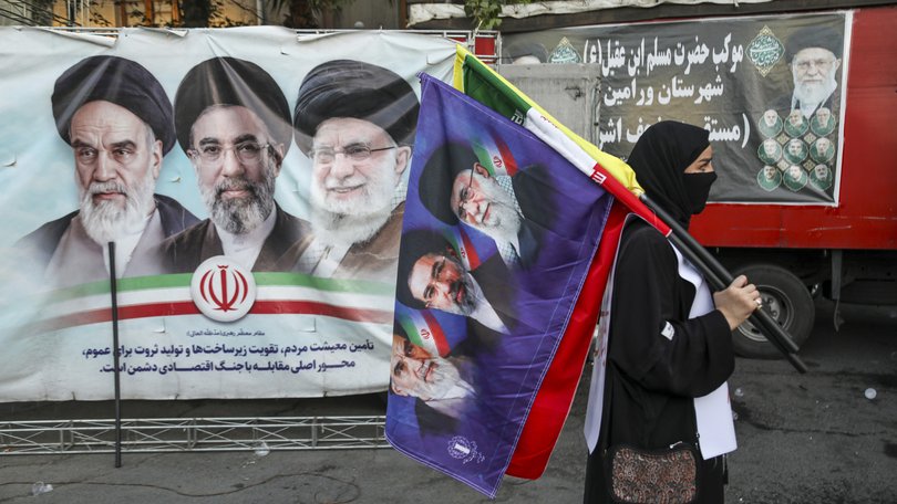 People in Tehran gather in support of Iran’s new leader, Seyyed Mojtaba Khamenei, while holding the Iranian flag and images of both the new and former leaders of Iran.