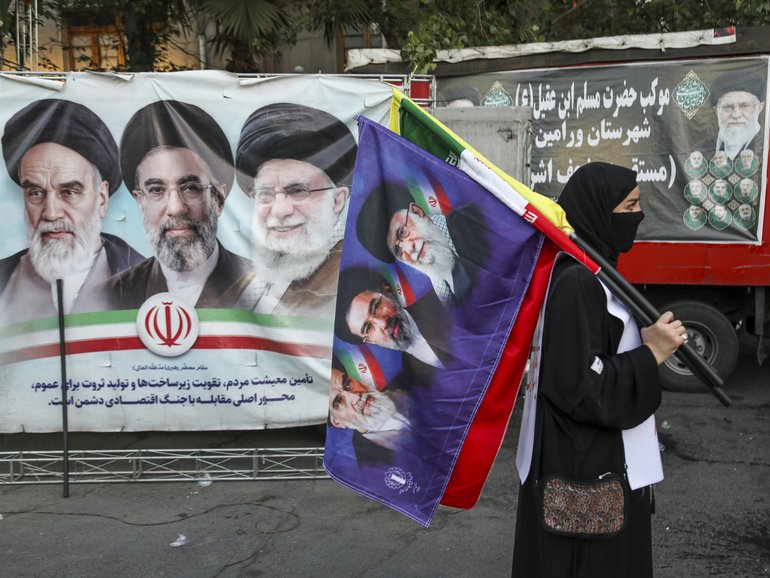 People in Tehran gather in support of Iran’s new leader, Seyyed Mojtaba Khamenei, while holding the Iranian flag and images of both the new and former leaders of Iran.