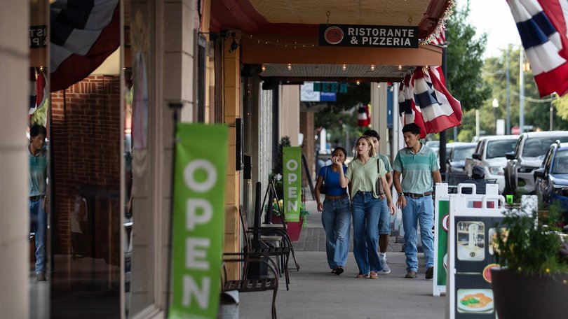 People walk along North Main Street in downtown in Bastrop, Texas.