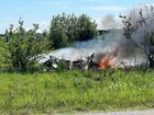 The wreckage of a plane crash burns in a field in Butler.