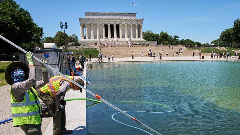 Workers are trying to clean green algae from Washington's Lincoln Memorial Reflecting Pool. 