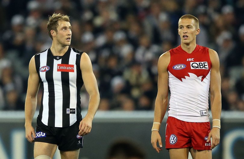 Ben Reid (L) of the Magpies and brother Sam Reid of the Swans look ahead during the round nine AFL match between the Collingwood Magpies and the Sydney Swans at Melbourne Cricket Ground on May 24, 2013 in Melbourne, Australia.