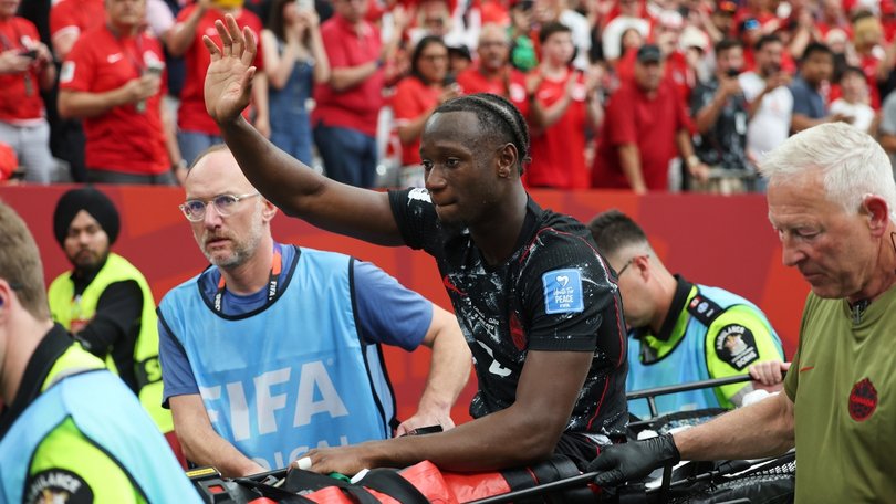 Ismael Kone waves to the crowd as he leaves on a stretcher.