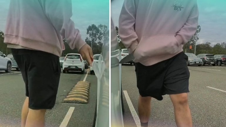 Security footage from the Eight Mile Plains park-and-ride shows a hooded man scanning the area before drawing a large knife and dragging the blade along the Tesla.