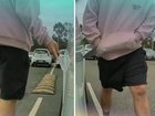 Security footage from the Eight Mile Plains park-and-ride shows a hooded man scanning the area before drawing a large knife and dragging the blade along the Tesla.