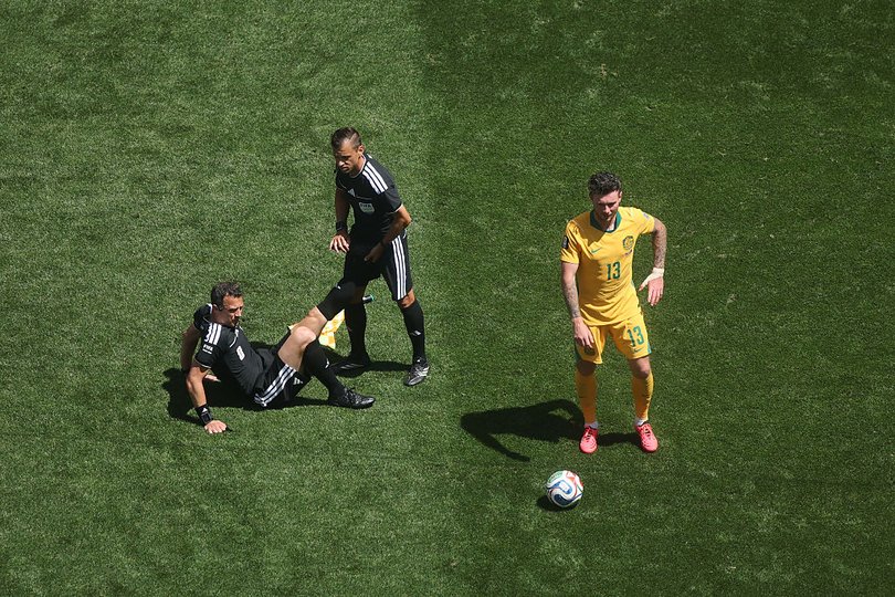 Referee Felix Zwayer gets help stretching with his cramping leg during the World Cup clash between between the USA and Australia.
