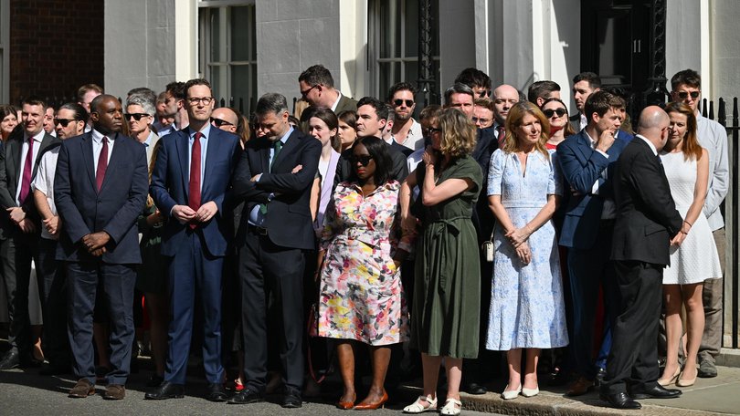 Downing Street staff and members of the cabinet watch on.