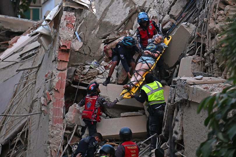 Rescue workers carry a person on a stretcher out of a collapsed building following an earthquake in Caracas on June 24, 2026. 