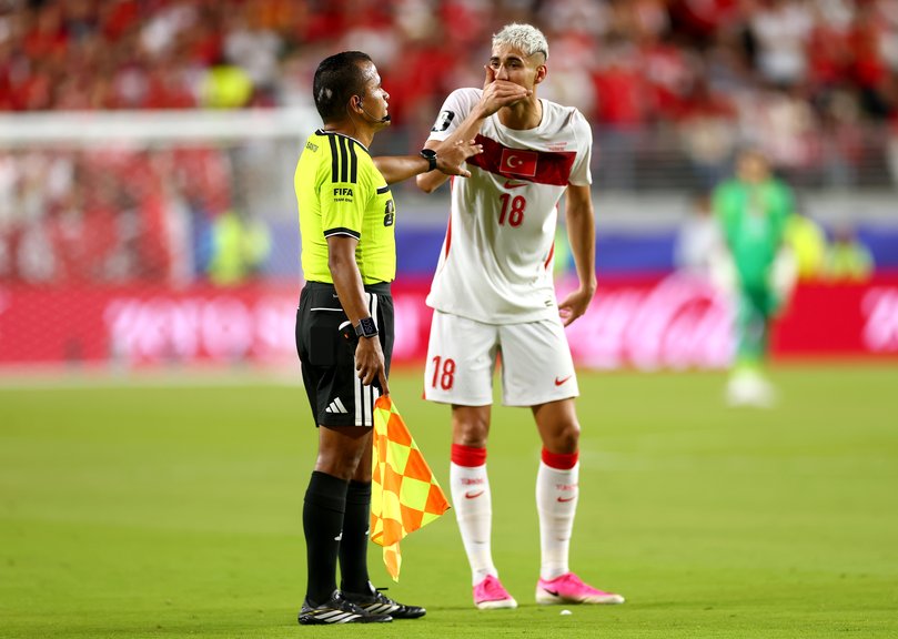 Mert Muldur #18 of Turkiye flags Miguel Almiron #10 (not pictured) of Paraguay for covering his mouth.