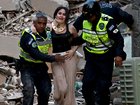 Municipal police officers evacuate an injured victim from a collapsed building in Caracas.