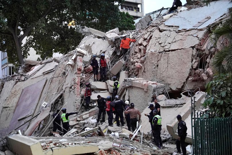 Rescuers search for victims in a collapsed building.