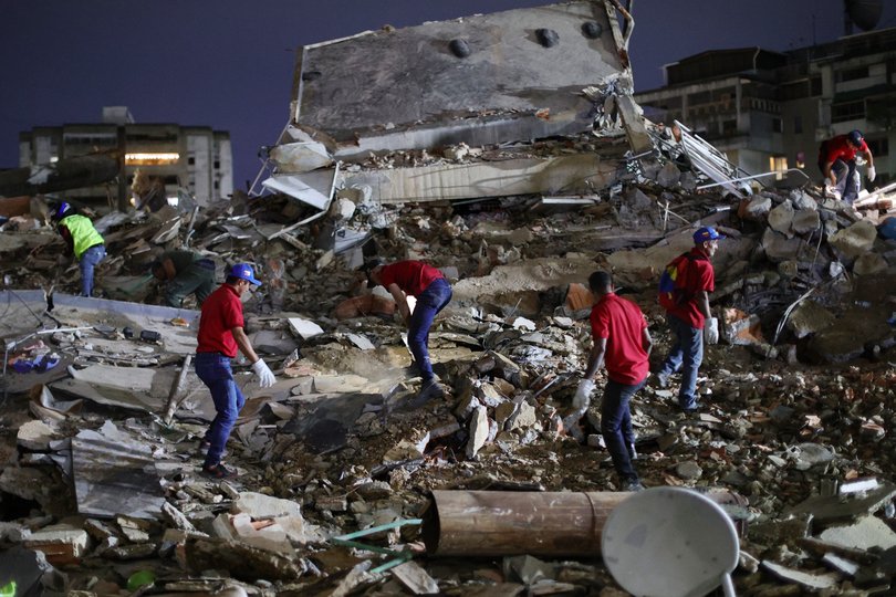 Responders search for victims in a demolished building at San Bernardino.