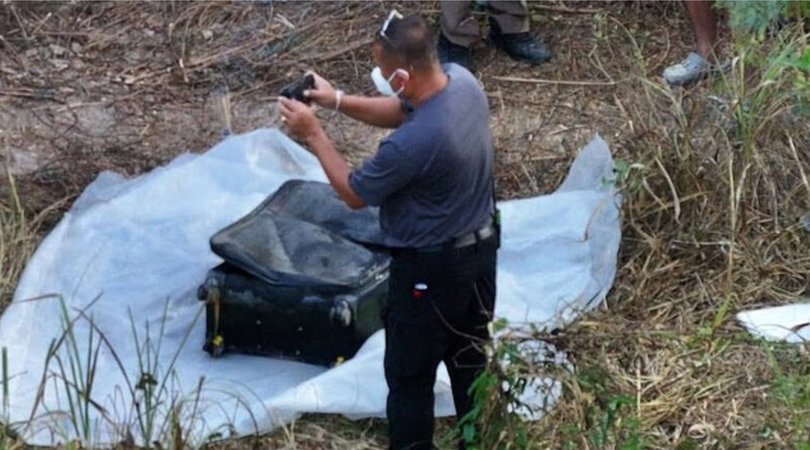 Police officers with a suitcase that contained a body.
