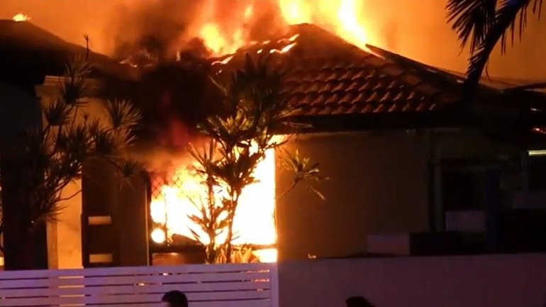 A man has died and two are fighting for life after a house fire at Hope Island.