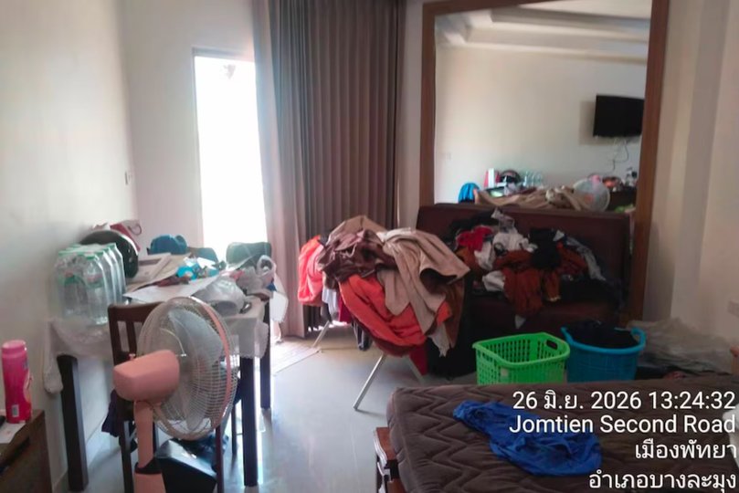 Piles of clothes are strewn throughout the living area.