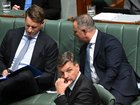 Shadow industry minister Andrew Hastie speaks to shadow treasurer Tim Wilson as Australian Opposition Leader Angus Taylor looks on during Question Time.