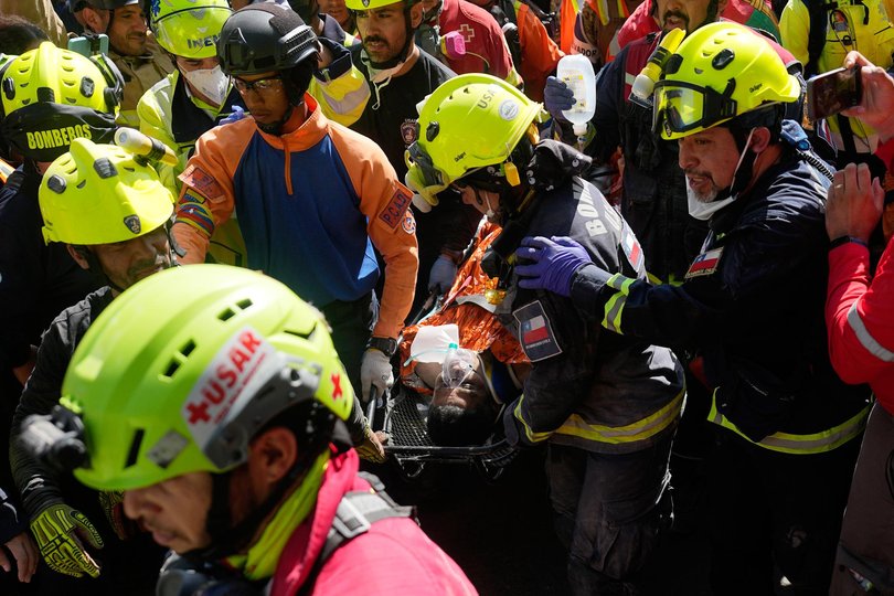 Rescue workers carry Hernn Alberto Gil Flores Gil after he was pulled from the rubble eight days after he was trapped by twin earthquakes that struck Catia La Mar, Venezuela, Thursday, July 2, 2026. (AP Photo/Fernando Vergara)