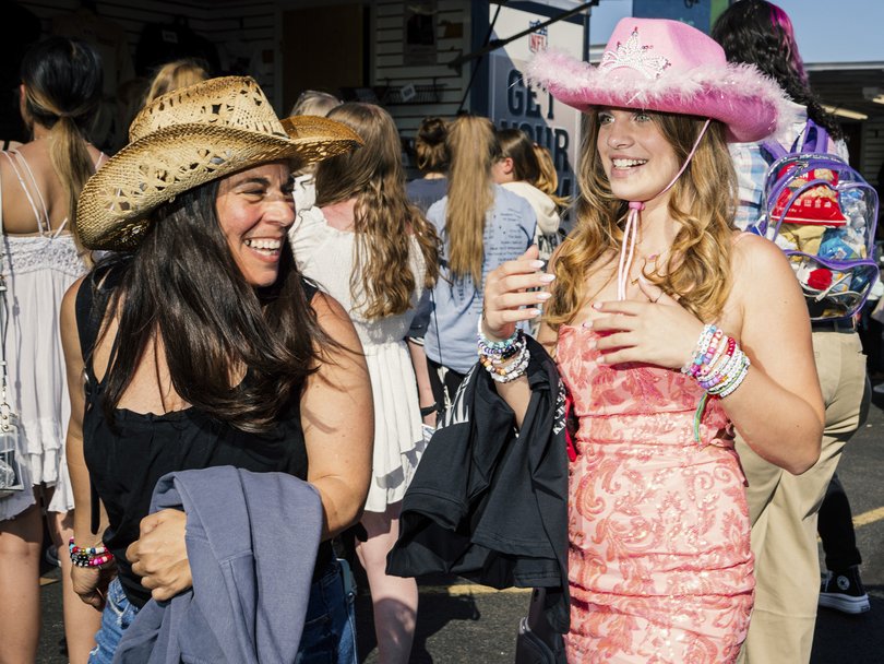 Taylor Swift fans buy tour merchandise outside the stadium before a show.