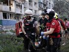 Ukrainian Red Cross members carry an injured resident from a collapsed residential building after a missile attack by Russian forces.