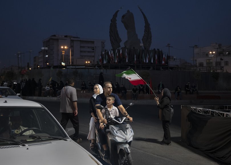 A mourner of Ayatollah Ali Khamenei waves an Iranian flag at Enghelab Square in Tehran, on Friday, July 3, 2026.